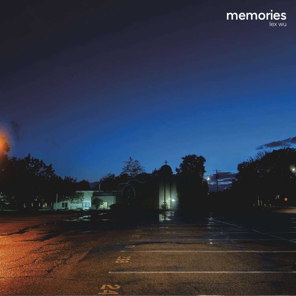 An empty parking lot at dusk, with a building in the background