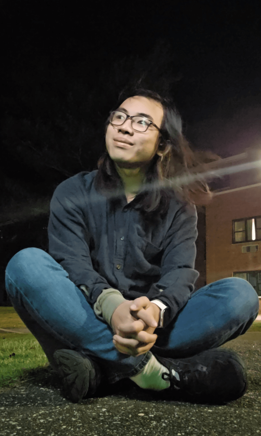 Lex Wu sitting outside, looking to the left.